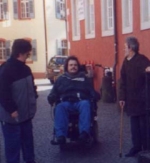 Personen mit Rollstuhl und Gehstock bei einer Ortsbegehung